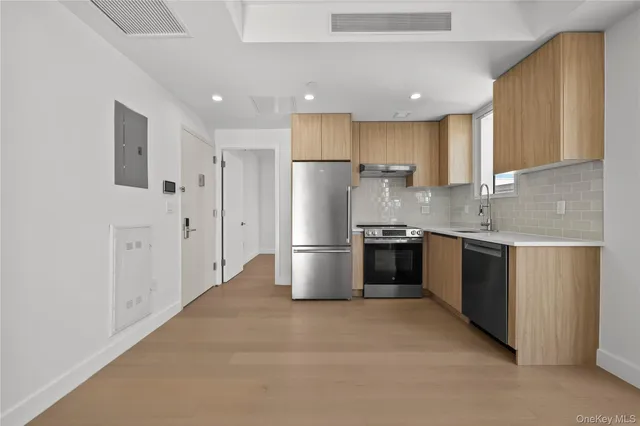 a kitchen with stainless steel appliances a refrigerator sink and cabinets