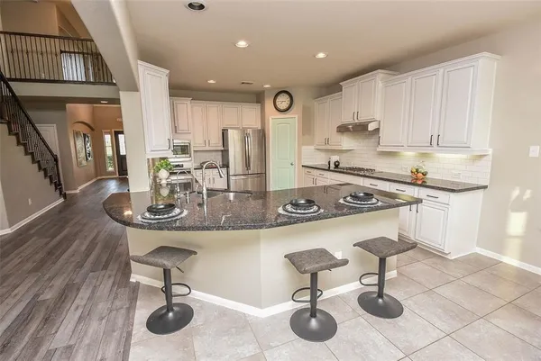 a kitchen with a sink appliances and cabinets