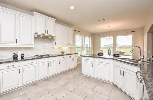 a large kitchen with white cabinets