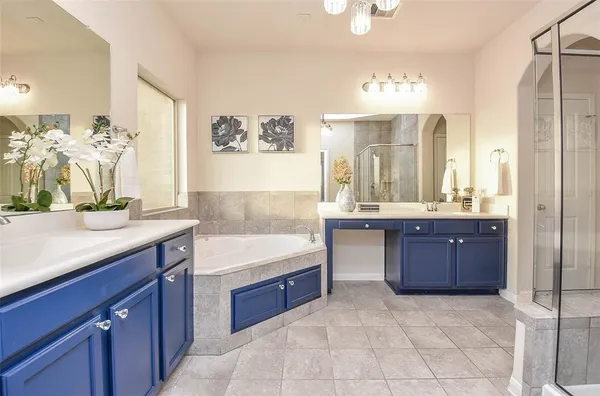a spacious bathroom with a granite countertop sink a mirror and a bathtub