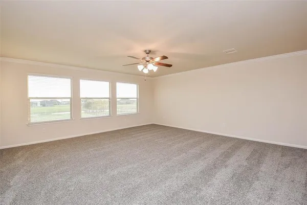 an empty room with a window and a ceiling fan