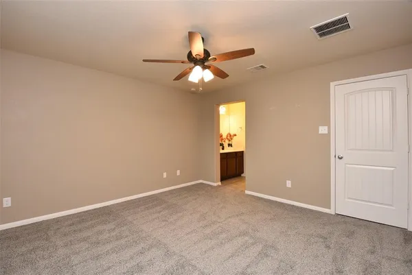 an empty room with closet and a chandelier fan