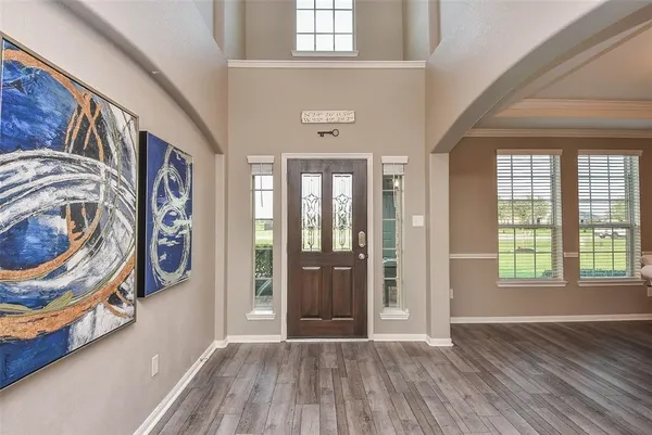 a view of a hallway with wooden floor and windows