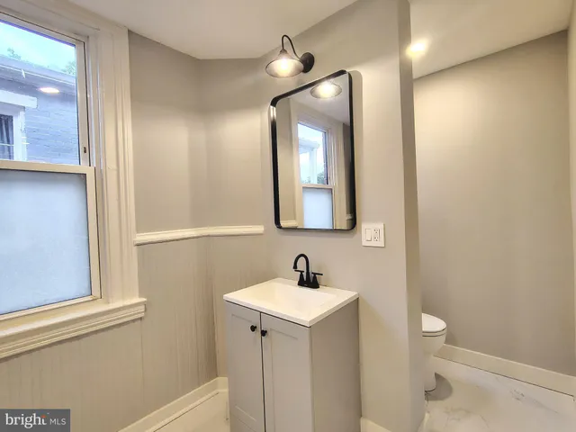 a bathroom with a toilet sink and mirror