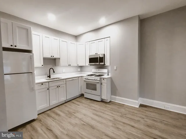 a kitchen with granite countertop white cabinets and stainless steel appliances
