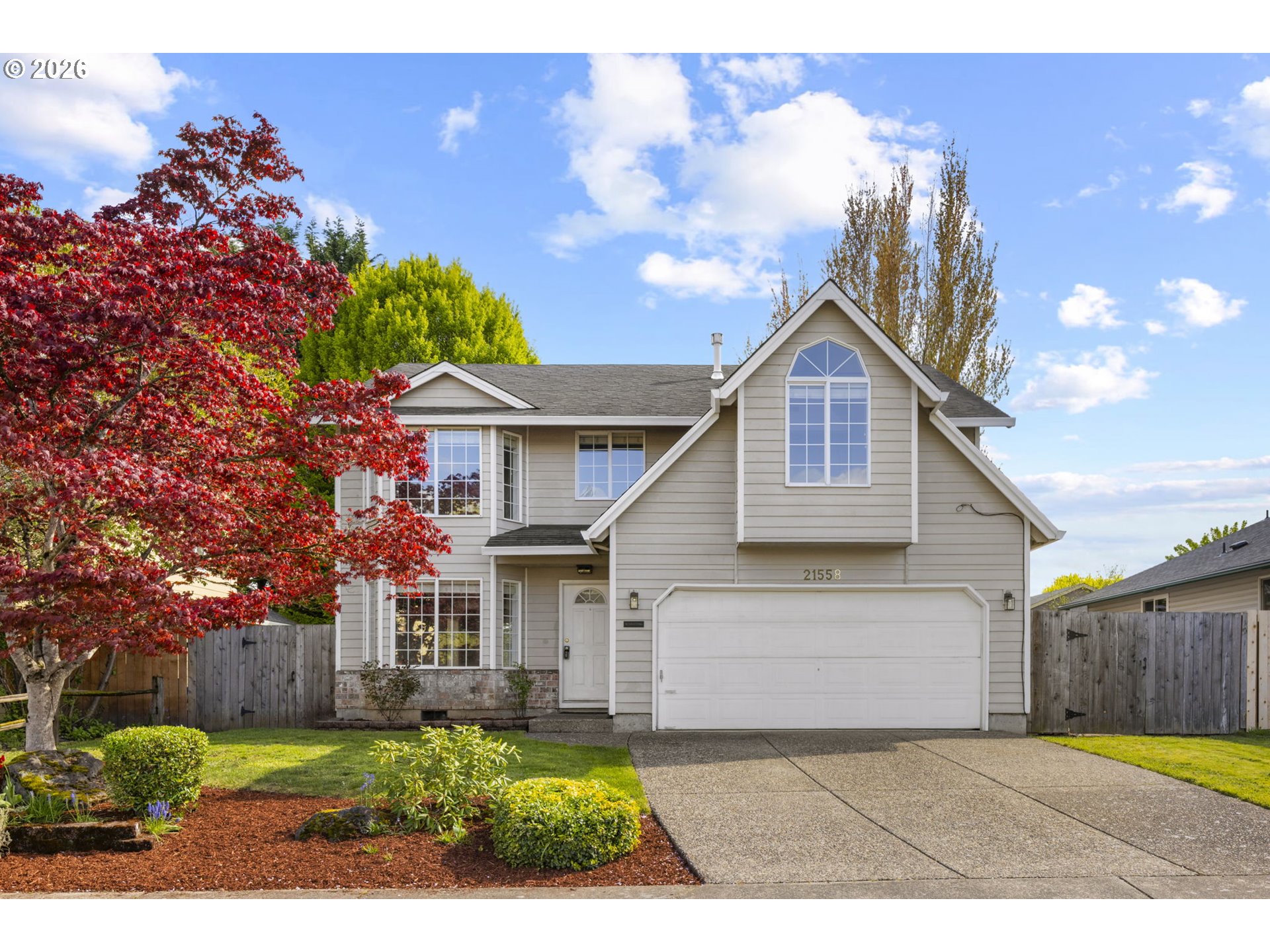 a view of a house with a yard and potted plants
