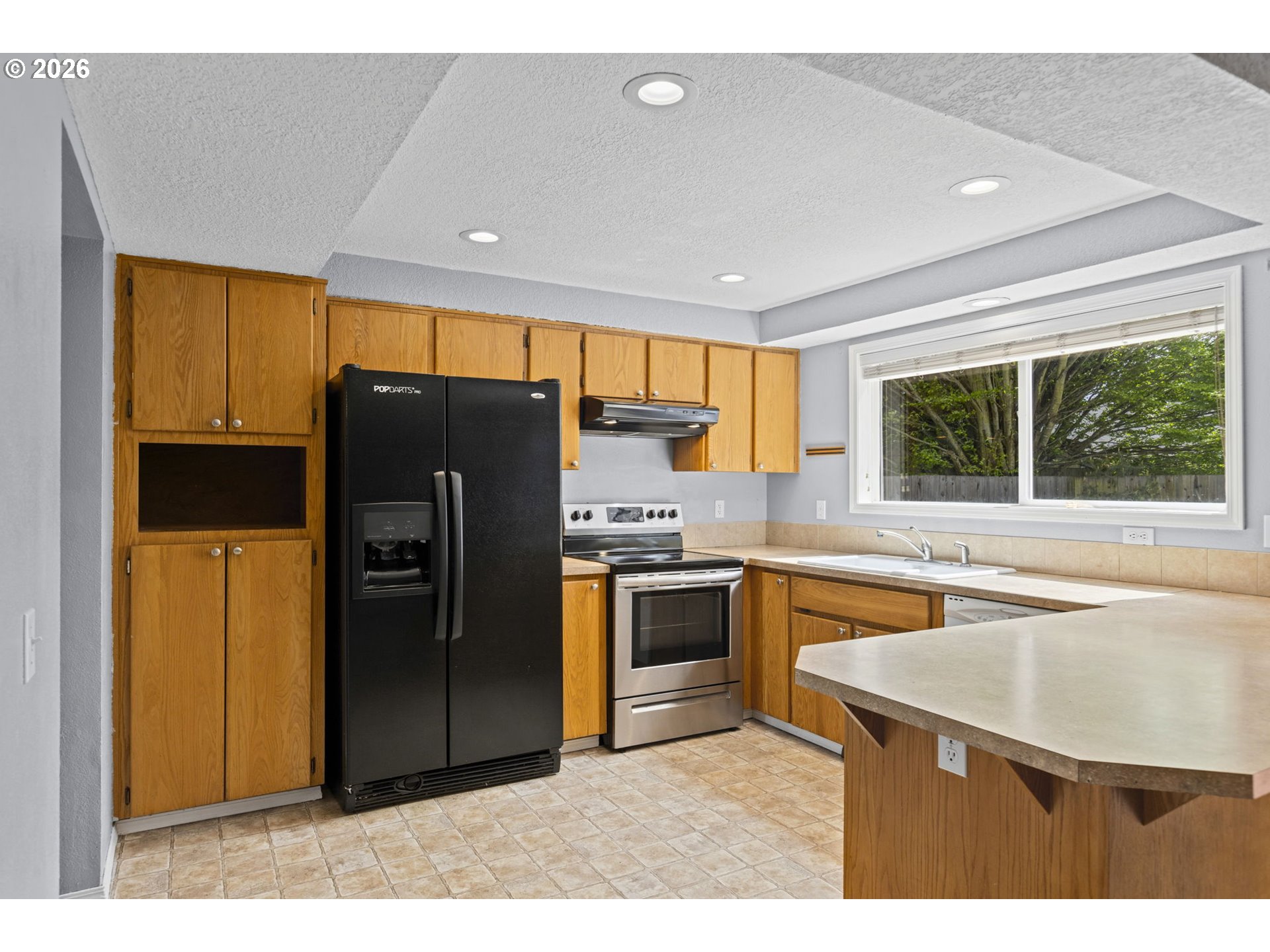 21558 Southwest Longacre Street Beaverton, OR 97003 - Photo 13 of 41 a kitchen with stainless steel appliances granite countertop a refrigerator a sink a stove and island