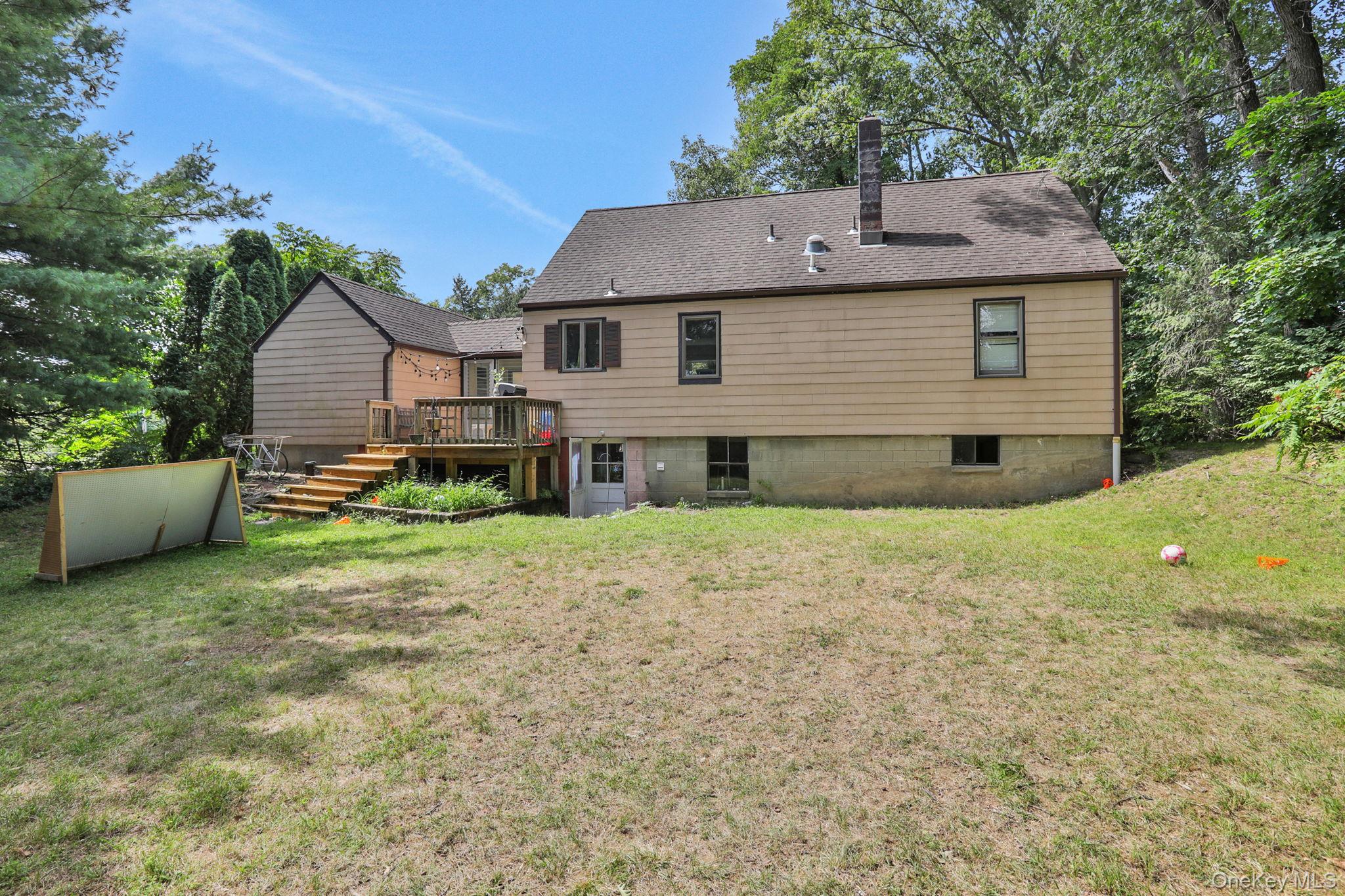 27 Osborne Hill Road Wappingers Falls, NY 12590 - Photo 23 of 31 Back of house with a chimney, a wooden deck, a lawn, and roof with shingles