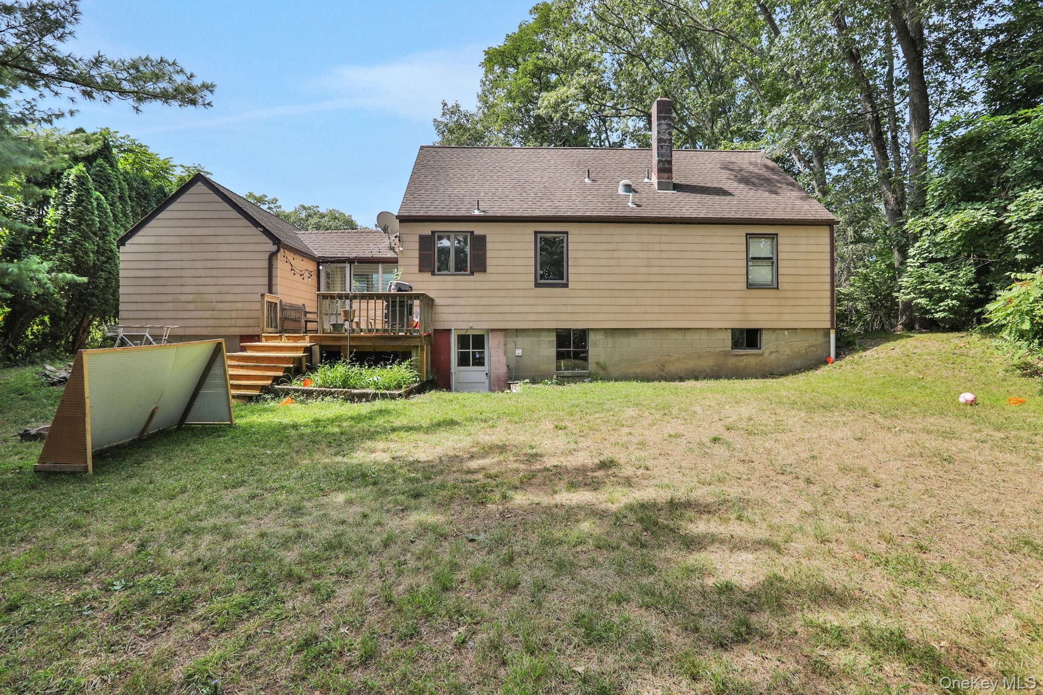 27 Osborne Hill Road Wappingers Falls, NY 12590 - Photo 24 of 31 Back of house featuring a chimney, a lawn, a deck, and a shingled roof