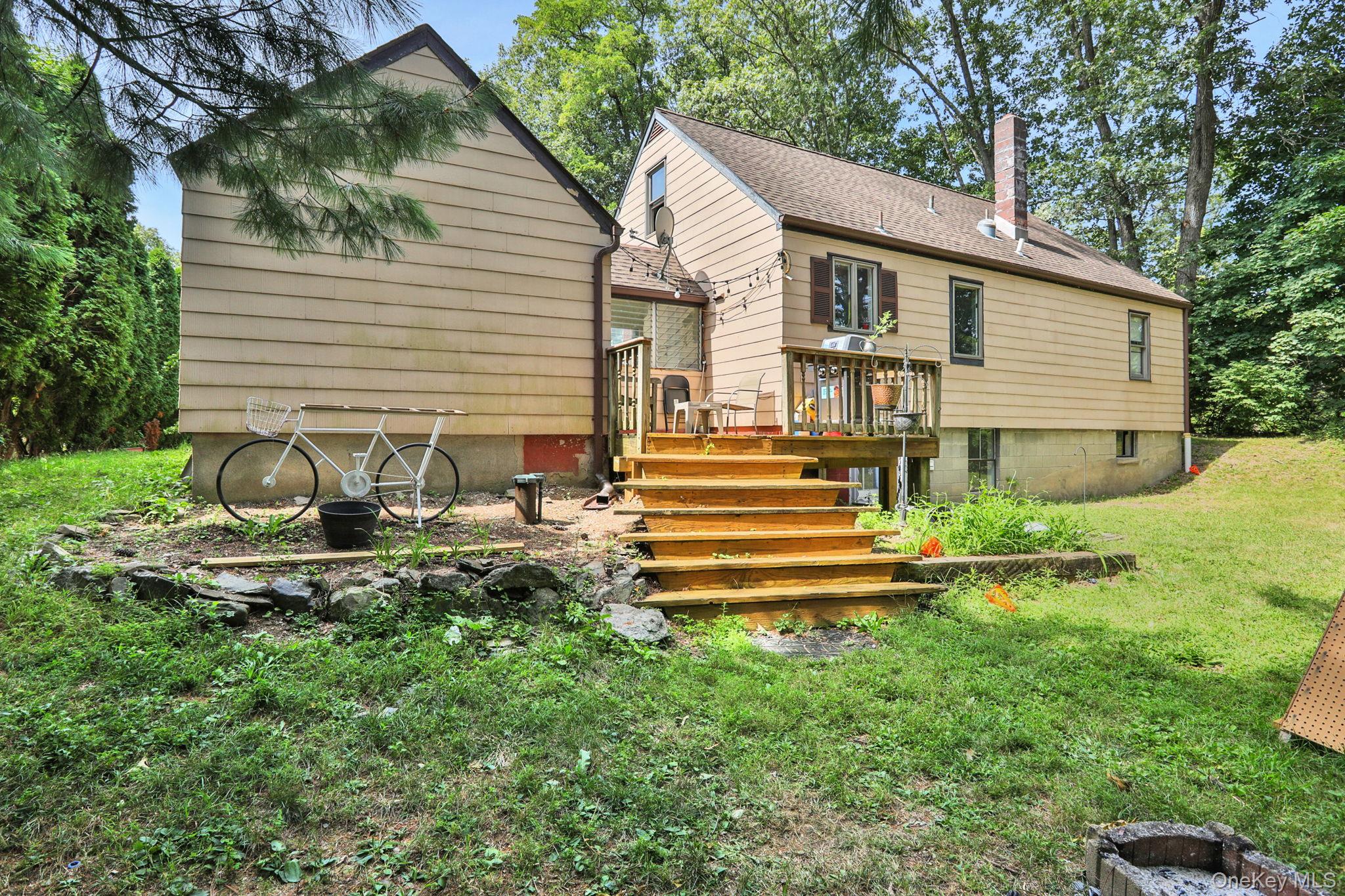 27 Osborne Hill Road Wappingers Falls, NY 12590 - Photo 25 of 31 Rear view of property featuring a wooden deck, a chimney, a yard, and stairway