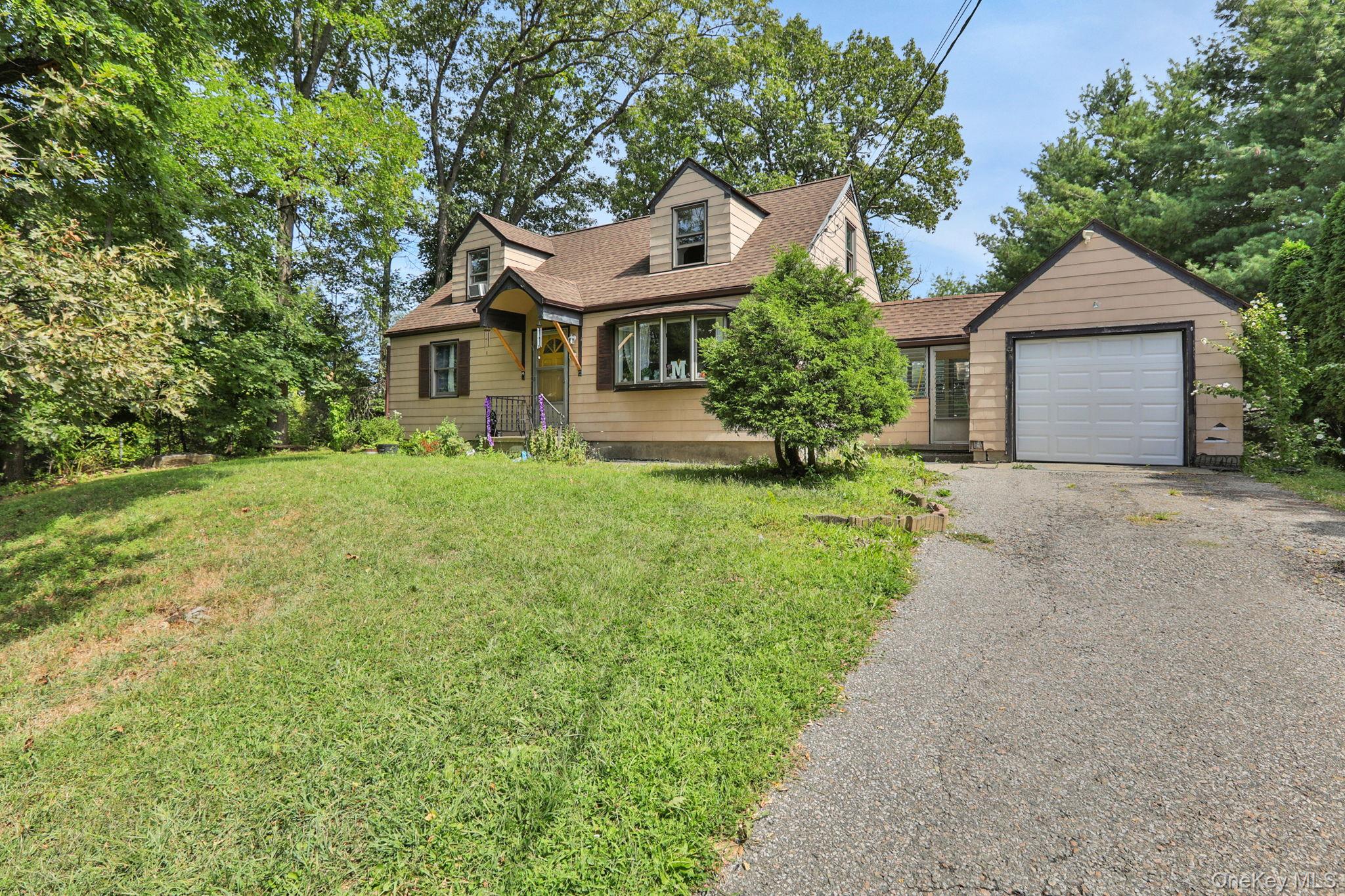 27 Osborne Hill Road Wappingers Falls, NY 12590 - Photo 4 of 31 New england style home featuring driveway, roof with shingles, a garage, and a front lawn