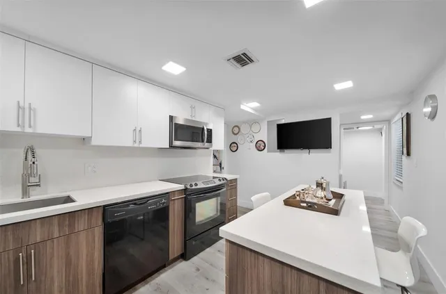 a kitchen with stainless steel appliances a sink stove and microwave
