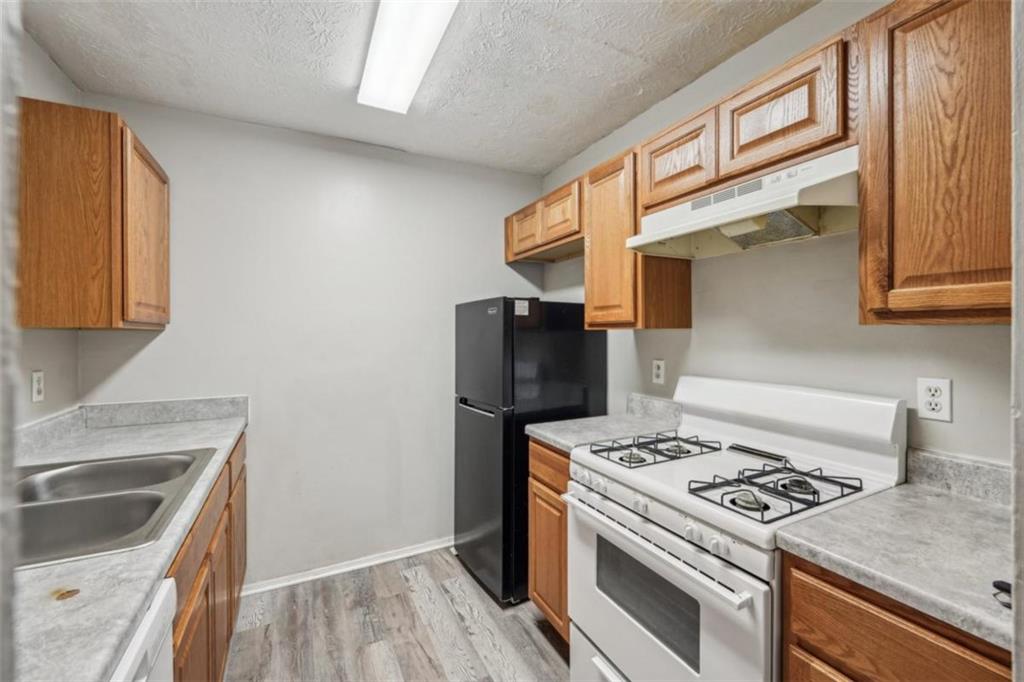 703 Pine Tree Trail Atlanta, GA 30349 - Photo 13 of 32 a kitchen with a stove and a refrigerator
