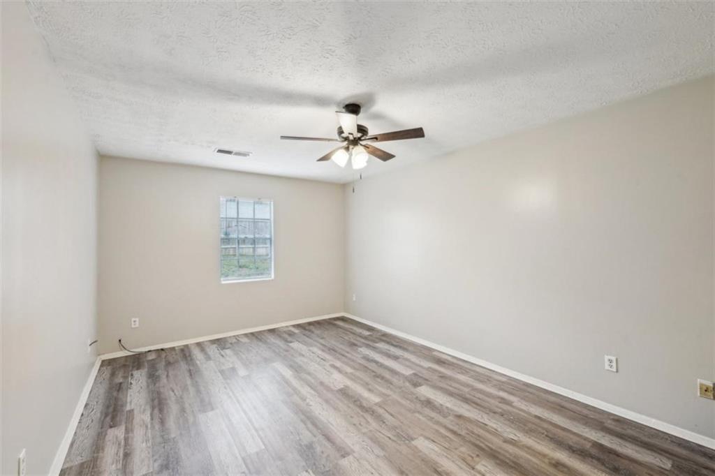 703 Pine Tree Trail Atlanta, GA 30349 - Photo 19 of 32 wooden floor in an empty room with a window
