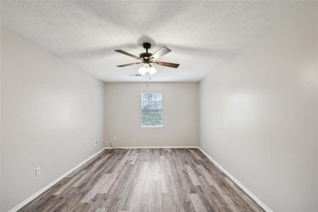 703 Pine Tree Trail Atlanta, GA 30349 - Photo 20 of 32 wooden floor in an empty room with a window