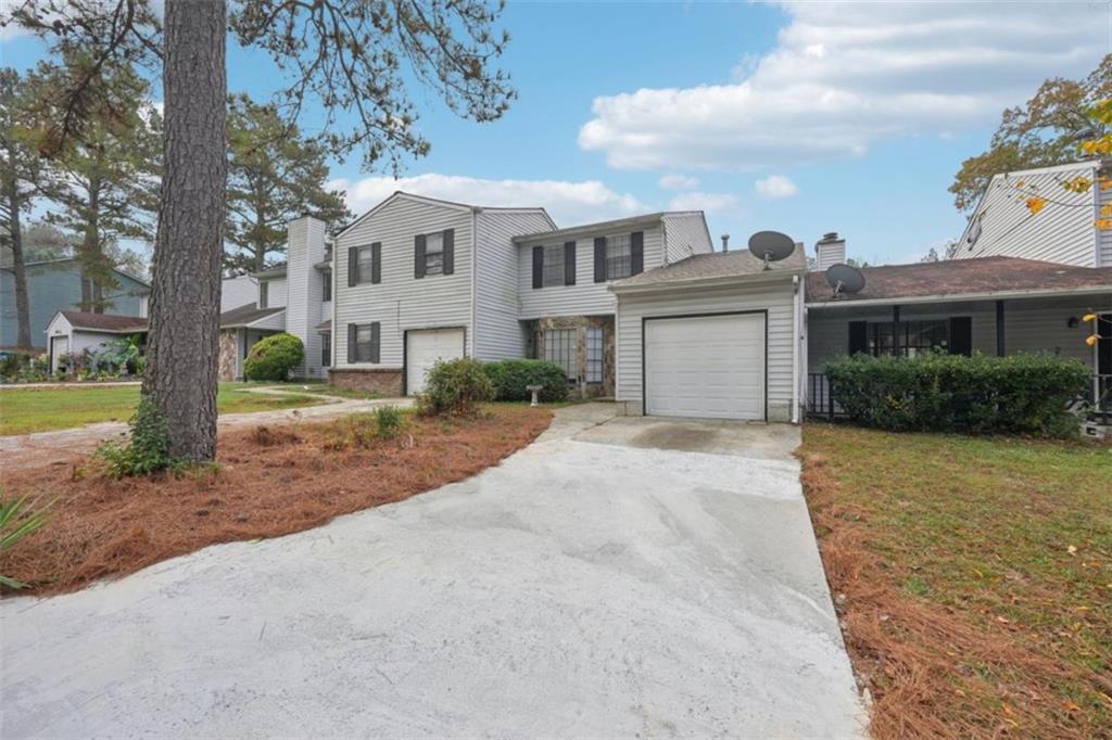 703 Pine Tree Trail Atlanta, GA 30349 - Photo 2 of 32 a front view of a house with a yard and potted plants
