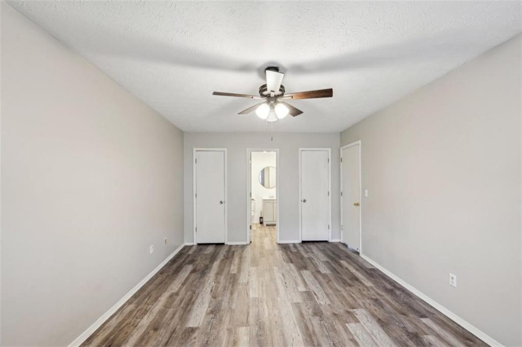 703 Pine Tree Trail Atlanta, GA 30349 - Photo 22 of 32 a view of a room with wooden floor and a ceiling fan
