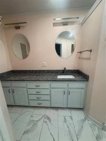 a bathroom with a granite countertop double vanity sink and a mirror