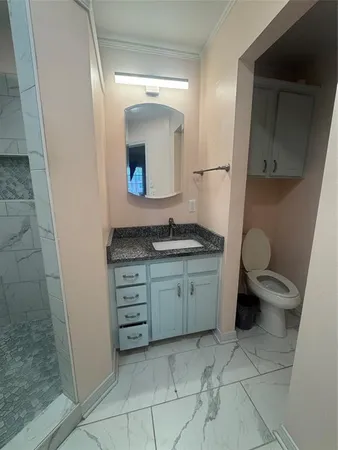 a spacious bathroom with a granite countertop sink toilet and mirror