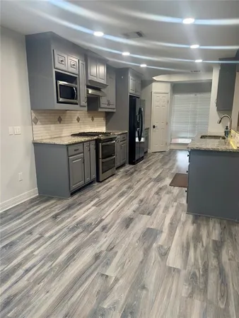 a large kitchen with a stove top oven and sink