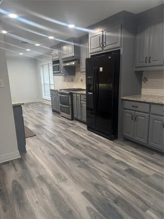 a kitchen with stainless steel appliances granite countertop a refrigerator and a sink