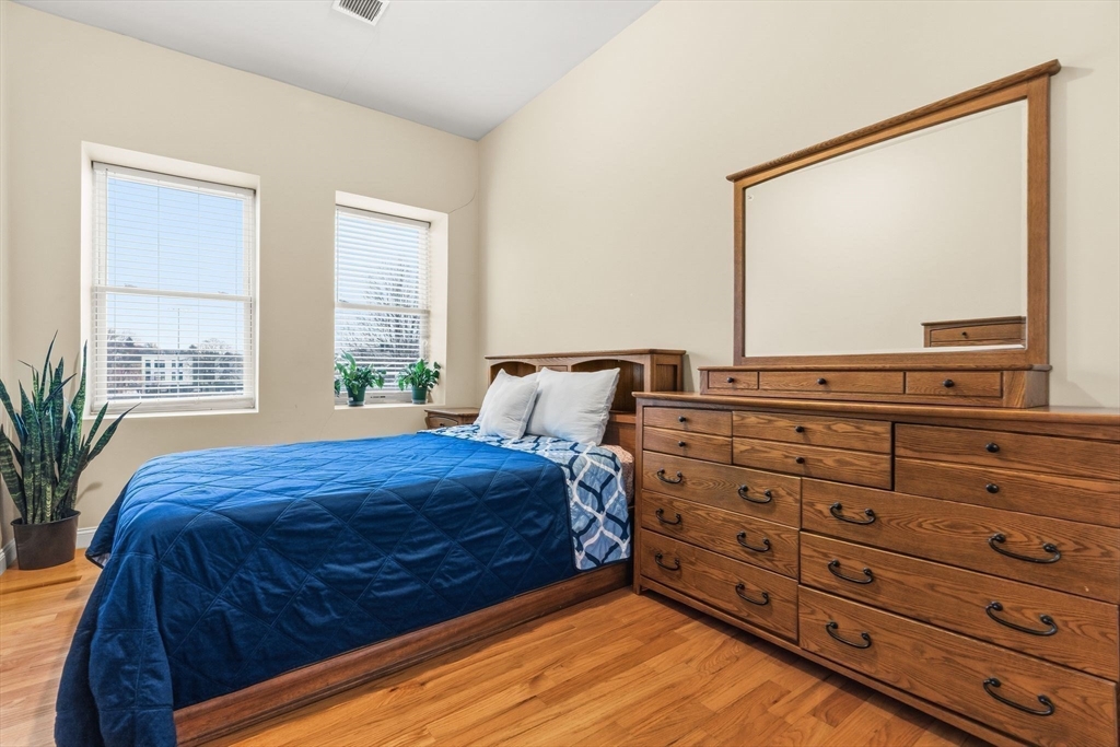 910 Saratoga Street, Unit 5 Boston, MA 02128 - Photo 11 of 24 a bedroom with a bed and two large window