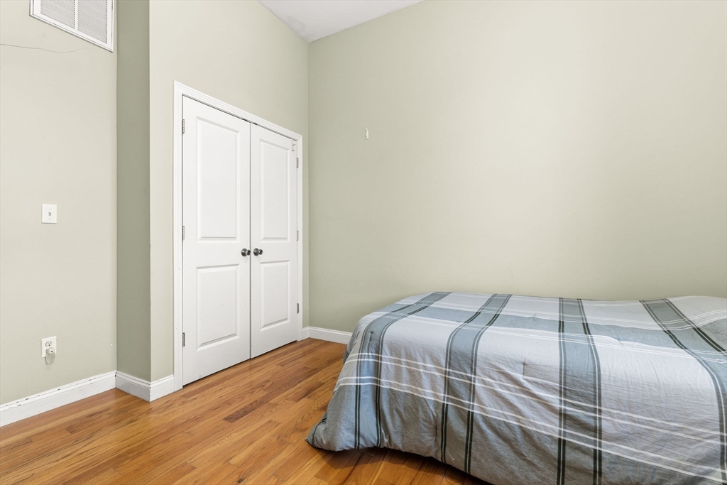 910 Saratoga Street, Unit 5 Boston, MA 02128 - Photo 15 of 24 a bedroom with a bed and wooden floor