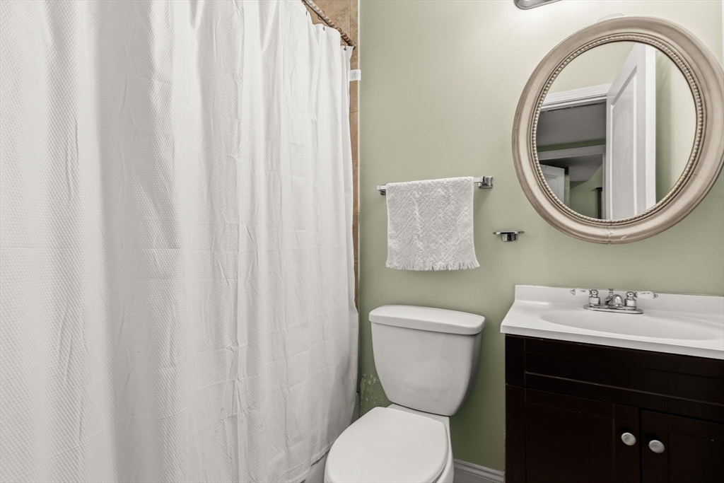 910 Saratoga Street, Unit 5 Boston, MA 02128 - Photo 17 of 24 a bathroom with a toilet a sink and a mirror