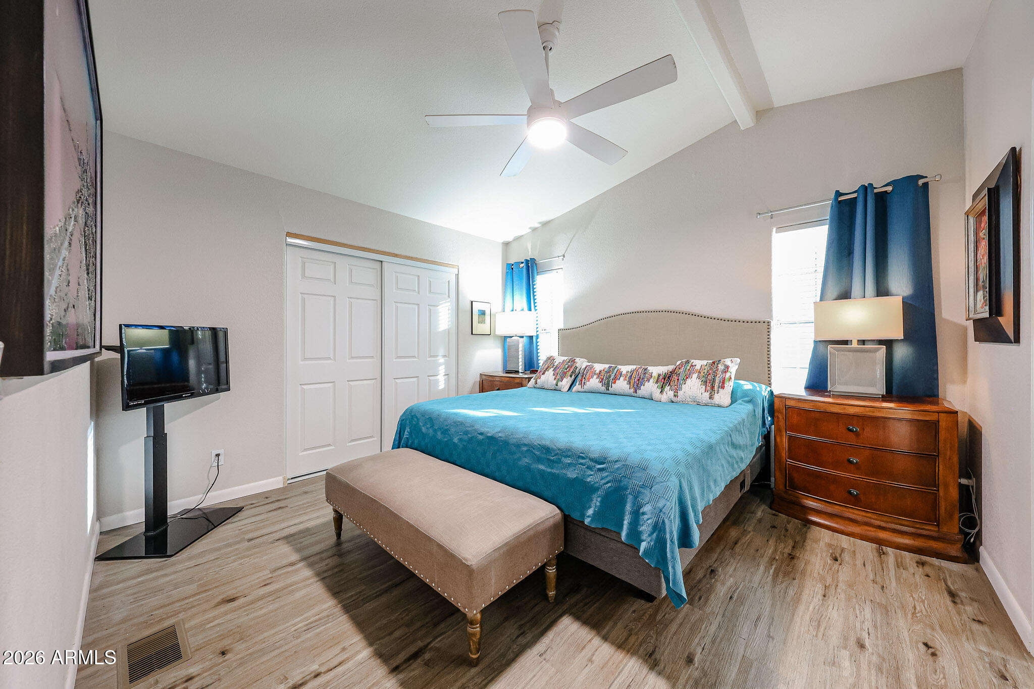 3901 East Pinnacle Peak Road, Unit 109 Phoenix, AZ 85050 - Photo 22 of 31 a bedroom with a bed and a flat tv screen on dresser