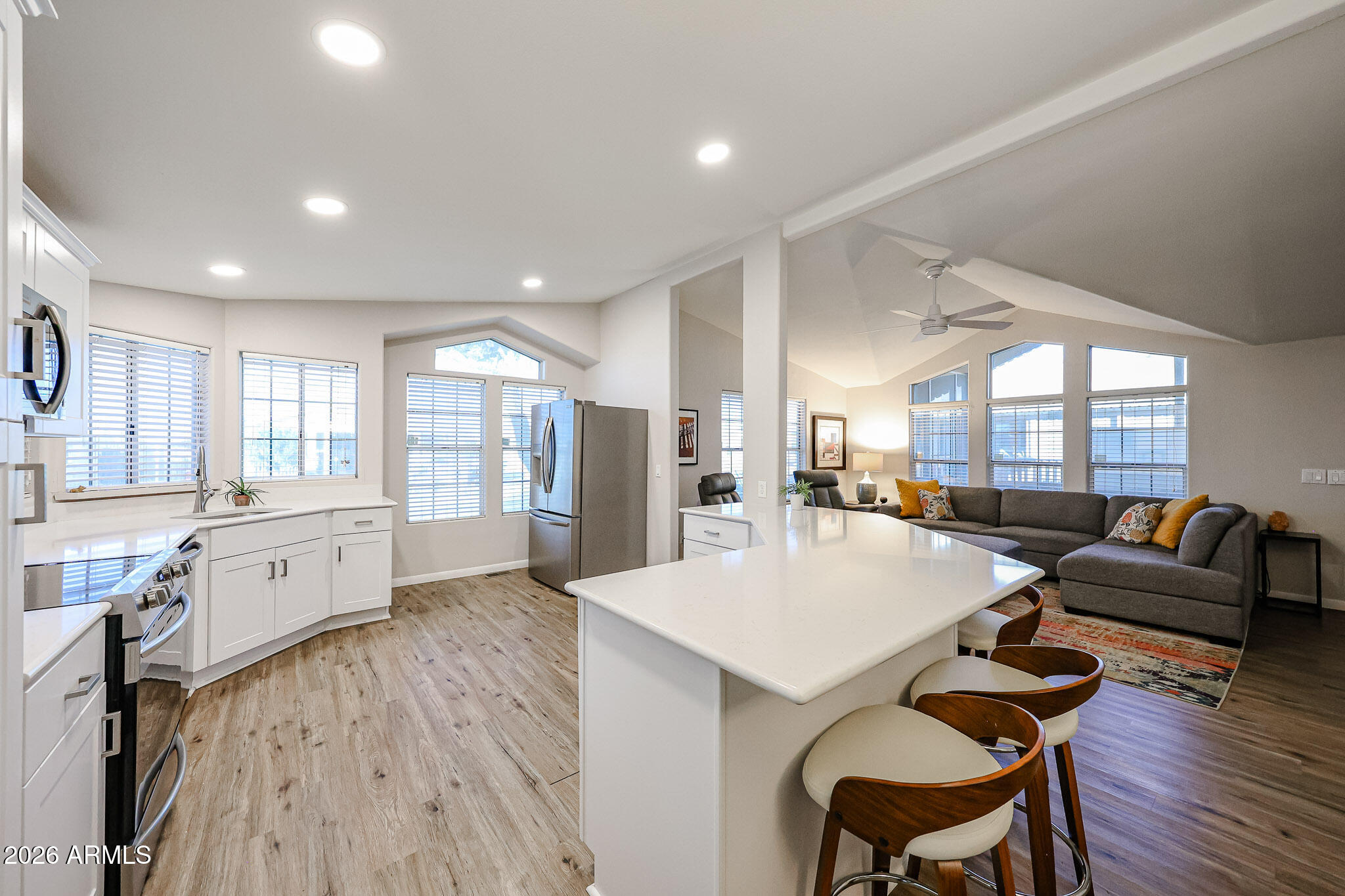 3901 East Pinnacle Peak Road, Unit 109 Phoenix, AZ 85050 - Photo 10 of 31 a large living room with stainless steel appliances kitchen island granite countertop wooden floor and a large window