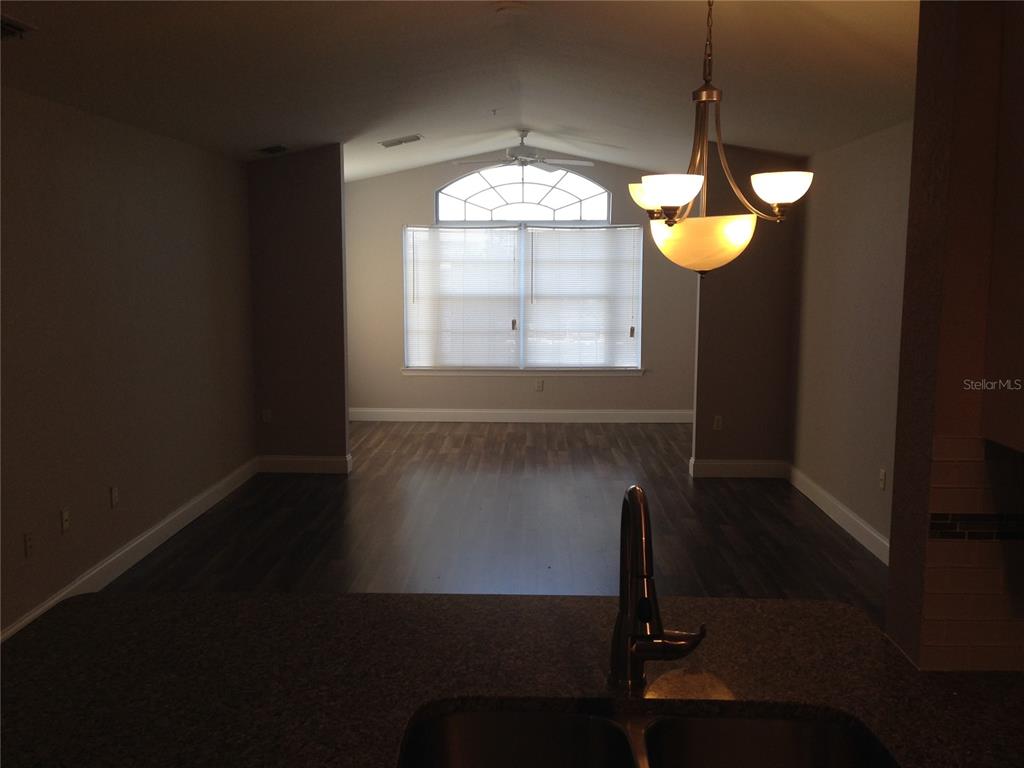 3373 South Kirkman Road, Unit 935 Orlando, FL 32811 - Photo 6 of 20 a view of wooden floor and chandelier in a room