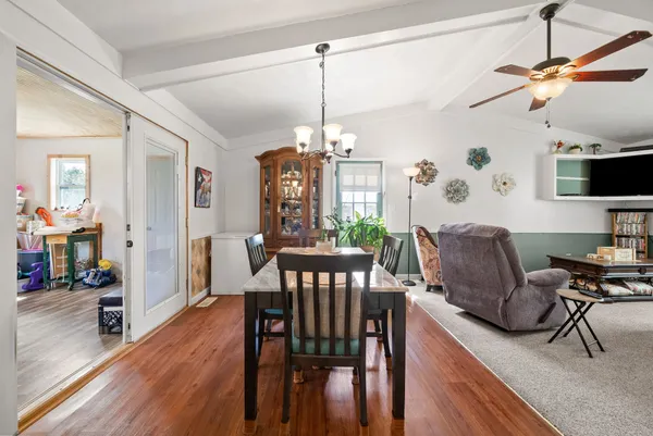 a view of a dining room with furniture a chandelier and wooden floor