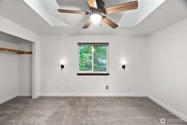 an empty room with a window and a fan