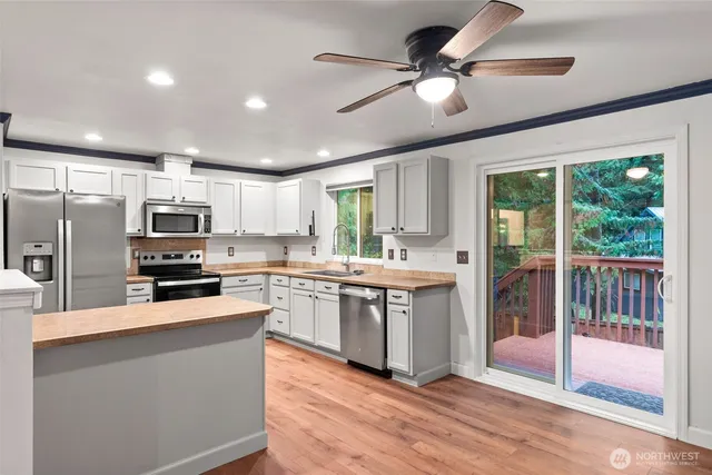 a kitchen with stainless steel appliances granite countertop a refrigerator a sink dishwasher a stove and a refrigerator