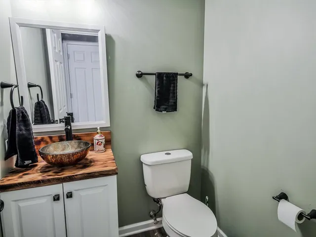 a bathroom with a toilet a sink and mirror