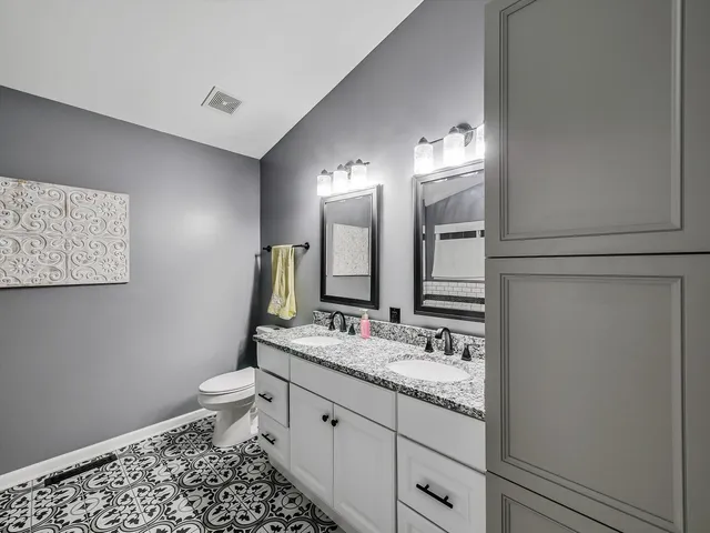 a bathroom with a sink a toilet and a mirror