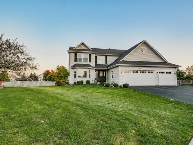 a view of a big house with a big yard and large trees