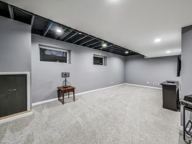 a view of an empty room with wooden floor and furniture