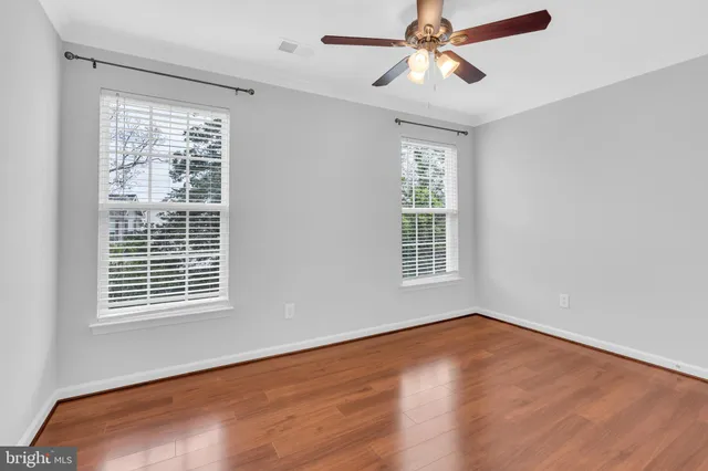 an empty room with a window and a fan
