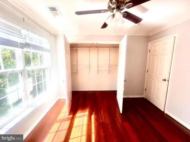 a view of empty room with wooden floor