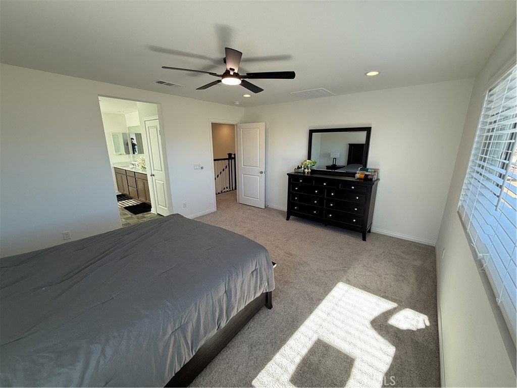 4461 Hickory Court Perris, CA 92571 - Photo 28 of 31 a bedroom with a bed and a chandelier