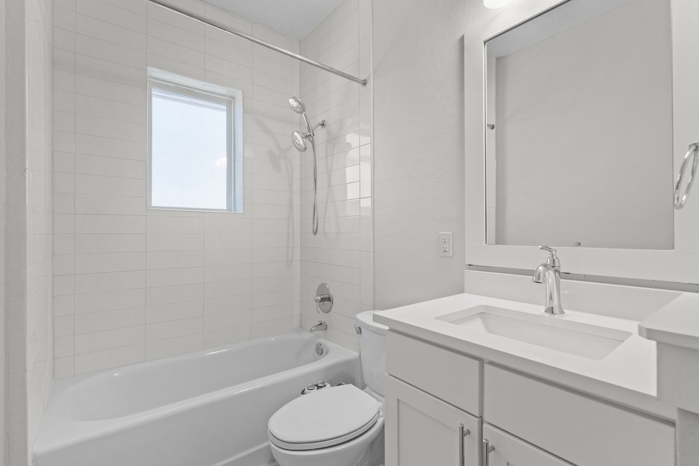 2827 Manor Road, Unit 2201 Austin, TX 78722 - Photo 21 of 40 Contemporary bathroom featuring a white vanity with an integrated sink, polished chrome faucet, and framed mirror