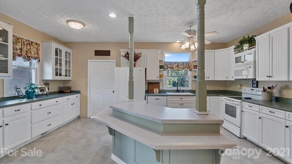 3928 Biggers Road Clover, SC 29710 - Photo 7 of 45 a large kitchen with stainless steel appliances granite countertop a stove a sink dishwasher a refrigerator and white cabinets with wooden floor