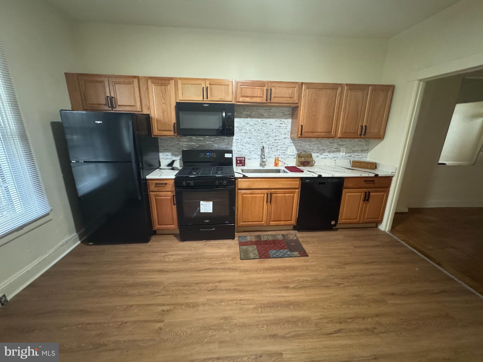 1638 Darley Avenue Baltimore, MD 21213 - Photo 2 of 15 a kitchen with stainless steel appliances wooden cabinets a stove top oven a sink and dishwasher