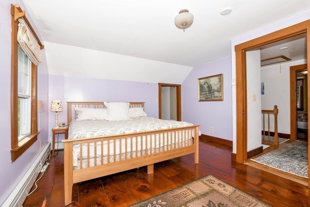 56 Marion Road Rochester, MA 02770 - Photo 17 of 39 a bedroom with a bed and wooden floor