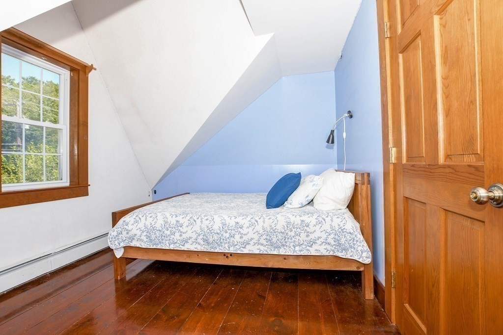 56 Marion Road Rochester, MA 02770 - Photo 20 of 39 a bedroom with a bed and wooden floor