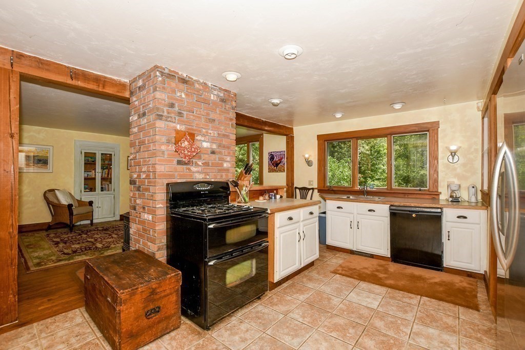 56 Marion Road Rochester, MA 02770 - Photo 8 of 39 a kitchen with stainless steel appliances granite countertop a stove top oven a sink dishwasher a dining table and chairs with wooden floor