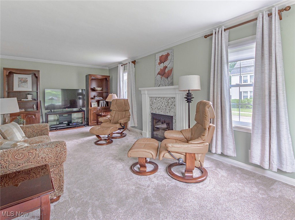 695 Ecton Road Akron, OH 44303 - Photo 4 of 26 The living room features updated carpet, a soft earth-tone paint, and a recently updated fireplace facade. Windows on two sides allow an abundance of natural light to flow through this space.