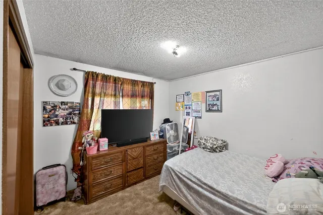 a bedroom with furniture and a flat screen tv