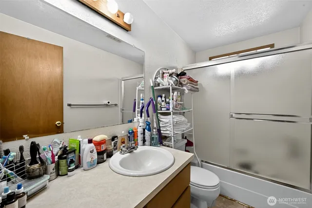 a bathroom with a sink a toilet and shower